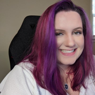 Desiree is a white, middle aged woman with shoulder length pink and purple hair.